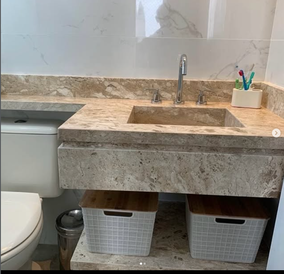Bancada e cuba esculpida em mármore travertino em lavabo